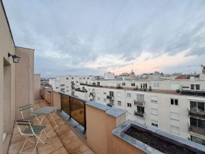 a balcony with chairs and a view of a city at Appartement "Le Biarritz" - vue Cathédrale et Parking gratuit in Reims