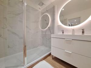 a bathroom with a shower and a sink and a mirror at Appartement "Le Biarritz" - vue Cathédrale et Parking gratuit in Reims +37 photos