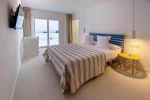 - une chambre avec un lit, une table jaune et une télévision dans l'établissement HOTEL BINI, à Porto Cristo