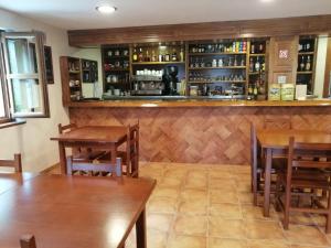 un restaurante con mesas de madera y un bar en El Caleyon, en Bulnes