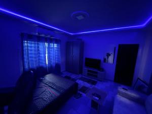 a living room with a couch and a blue light at Studio cosy avec vaste terrasse in Cotonou