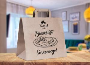 a paper bag with a sandwich on a table at OSTOJA RESIDENCE VIP ze strefą relaksu i pokojem zabaw by Royal Aparts in Szklarska Poręba