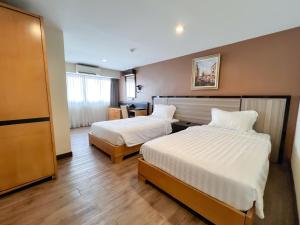 a hotel room with two beds with white sheets at Hallmark Express Hotel in Melaka