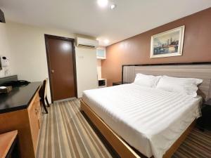 a hotel room with a large white bed in it at Hallmark Express Hotel in Melaka