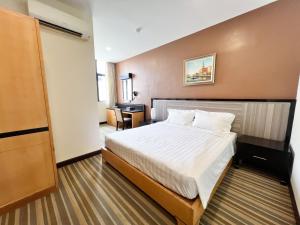 una camera d'albergo con letto e scrivania di Hallmark Express Hotel a Malacca