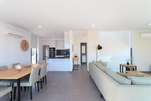 a dining room and living room with a table and chairs at Villa uitzicht baai met jacuzzi in Salir do Porto
