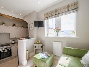 uma cozinha e sala de estar com um sofá e uma mesa em 1 bed property in Holmfirth 82194 em Meltham