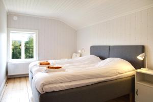 um quarto com uma grande cama branca e uma janela em B&B Bjärtrå em Hjälta