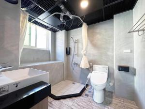 a bathroom with a sink and a toilet and a shower at 達魯瑪民宿-無停車位 in Hualien City