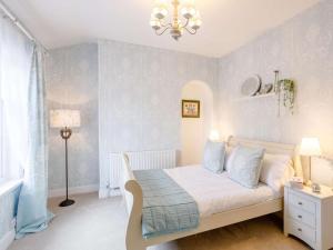 Un dormitorio con una cama con paredes azules y una lámpara de araña. en 1 Bed in Saltaire 83634 en Shipley