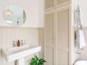 Baño blanco con lavabo y espejo en 1 Bed in Saltaire 83634 en Shipley