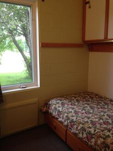 1 dormitorio con cama y ventana en Motel Econonuit, en Sherbrooke