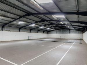 una pista de tenis en un gran edificio con luces en 1 Bed in Widemouth Bay 81124, en Poundstock