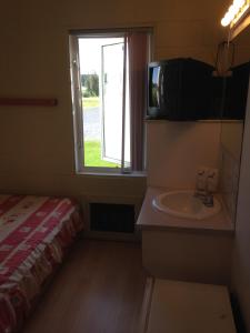 een kleine kamer met een wastafel en een magnetron bij Motel Econonuit in Sherbrooke