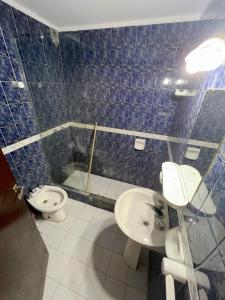 baño de azulejos azules con lavabo y aseo en Tony Center III en Las Toninas