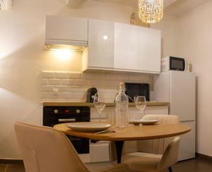 eine Küche mit einem Holztisch mit Weingläsern in der Unterkunft Appartement avec cour privée + clim séjour + wifi in Avignon