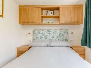 Ce lit se trouve dans une petite chambre dotée d'armoires en bois. dans l'établissement 2 bed property in Totnes 82871, à South Brent