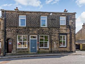 a brick house with a blue door and windows at 3 Bed in Holmfirth 83151 in Holmfirth