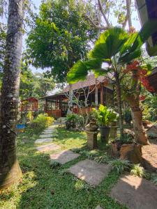 una casa con alberi e un passaggio pedonale di fronte ad essa di Mettaloka Guesthouse a Magelang
