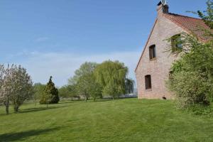 an old brick building in a field with trees at Les chambres du Vert Galant Le lever du soleil in Verlinghem