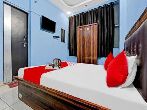 a bedroom with a large bed with red pillows at OYO Flagship Hotel Shivnath in Kānpur