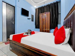 a bedroom with a bed with red pillows and a sink at OYO Flagship Hotel Shivnath in Kānpur