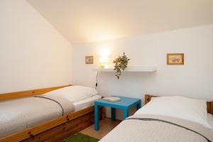 Zimmer mit 2 Betten und einem blauen Tisch in der Unterkunft Seepark Süssau Ferienhaus Seeadler 6 in Süssau