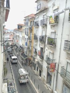 uma rua da cidade com carros estacionados no lado dos edifícios em Alfama Valle em Lisboa