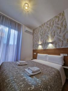 1 dormitorio con 1 cama grande y toallas. en Hostal A Nuestra Senora de La Paloma en Madrid