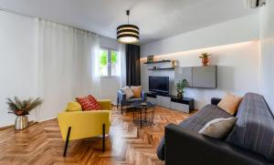 ein Wohnzimmer mit einem Sofa und einem TV in der Unterkunft Apartments Čolak in Zadar