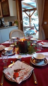 einen Tisch mit einem roten Tischtuch mit Tellern und Kerzen in der Unterkunft Casa Picca & Lotta in Radenthein