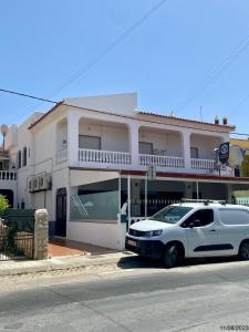 una macchina bianca parcheggiata di fronte a un edificio di BLife Aerya private rooms a Faro