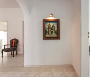 a picture on a wall in a hallway with a chair at Aerya private rooms in Faro