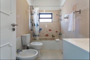 a bathroom with a toilet and a tub and a sink at BLife Aerya private rooms in Faro
