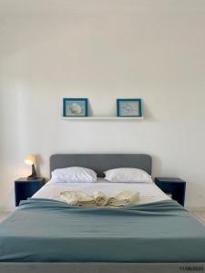 - un lit avec une couverture bleue et 2 oreillers dans l'établissement BLife Aerya private rooms, à Faro