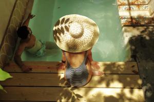 two children are sitting on the stairs in a swimming pool at FIXIE LOFTS - Colonial Villa Suites with Pool in Santo Domingo