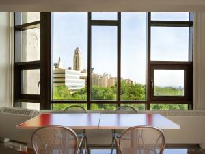 Ein Tisch und Stühle vor einem großen Fenster in der Unterkunft ZUM MTL Auberge d'été - Université de Montréal in Montreal