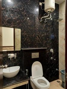 a bathroom with a white toilet and a sink at New Gokul Grand in Dehradun