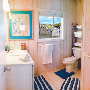 ein Bad mit einem WC, einem Waschbecken und einem Fenster in der Unterkunft Sea Smile in Staniel Cay