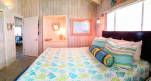 a bedroom with a large bed with colorful pillows at Sea Smile in Staniel Cay
