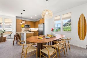 a kitchen and dining room with a wooden table and chairs at Alaula by AvantStay Gated Security Home w Valley Ocean Views in Waianae