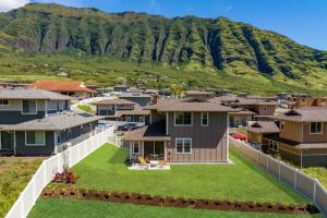 arial view of houses in a village with mountains in the background at Alaula by AvantStay Gated Security Home w Valley Ocean Views in Waianae
