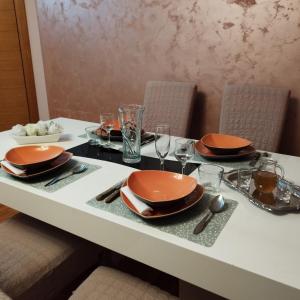 una mesa con platos y utensilios. en Family Star apartman en Čačak