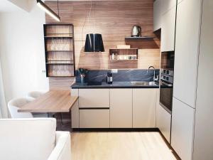 a kitchen with white cabinets and a black counter top at NEW Ana Design City Center Apartments in Pula