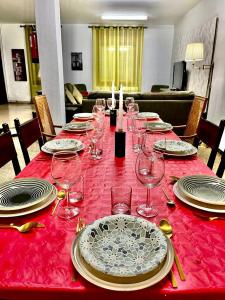 a red table with plates and wine glasses on it at Esplús Casa Rural in Binéfar