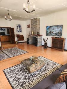 a large living room with a table and a fireplace at Mukala Lodge in Lusaka