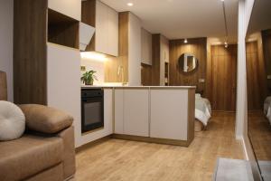 a kitchen with white cabinets and a living room at Suite JC1 CHIC in Murcia