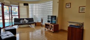 sala de estar con silla y TV en Albufeira Marina Villa 27, en Albufeira