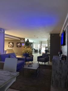 a living room with a blue couch and a christmas tree at Jolly Resort & Spa in Ponte di Legno