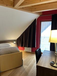 a bedroom with a bed and a desk and a table at Jolly Resort & Spa in Ponte di Legno